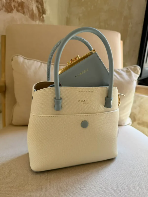 Bolso estructurado en tono beige con asas azul claro